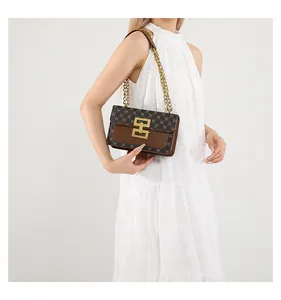Détail d'un sac à bandoulière vintage avec boucle dorée et chaîne sur un mannequin