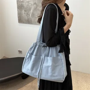 Large capacity light blue denim bucket bag with drawstring closure and outer pockets