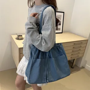 Large capacity blue denim tote bag with drawstring detail and front pockets for women