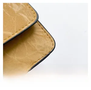 Close-up of yellow faux leather texture with contrast stitching and black edge painting