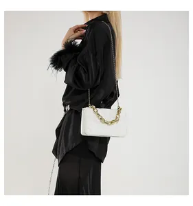Bolso bandolera blanco acolchado con cadena dorada gruesa lucido por una modelo