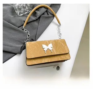 Detailed comparison of yellow bow-knot underarm bag and smartphone showing size scale