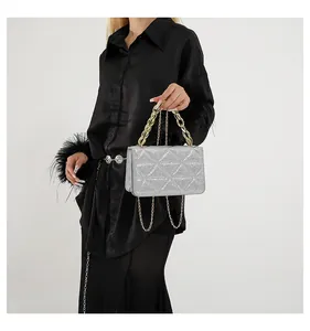Bolso de lentejuelas plateadas con acolchado triangular y asa de cadena dorada gruesa