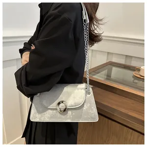 Détail de la texture mate argentée sur le petit sac à rabat avec bandoulière chaîne