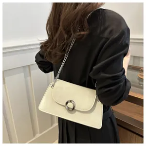 Détail du sac à bandoulière blanc avec anneau en métal argenté et bandoulière chaîne