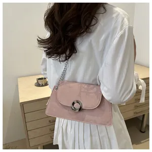 Détail du sac bandoulière en daim rose avec fermoir anneau argenté et chaîne