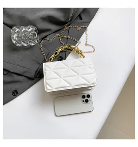 Mini bolso acolchado blanco con cadena dorada y smartphone para referencia de tamaño
