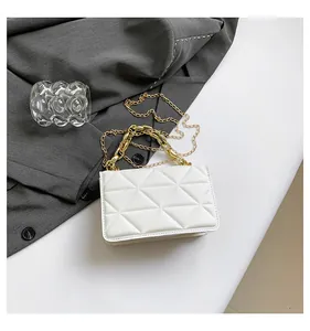 Detalle de bolso acolchado blanco con cadena dorada sobre fondo minimalista de estilo moderno