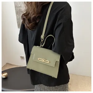 Détail du sac vert texture litchi avec boucle dorée et bandoulière réglable
