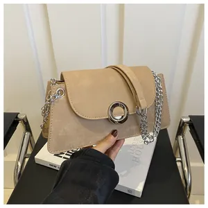 Détail du sac à bandoulière en daim beige avec grande boucle en argent et chaîne
