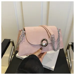 Détail du sac bandoulière rose en daim avec boucle argentée et bandoulière en chaîne