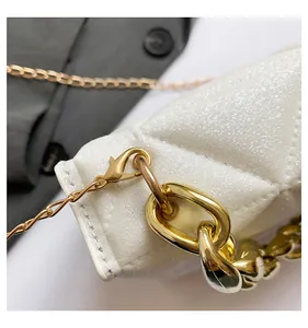 Detalle de bolso acolchado blanco perlado con cadena metálica dorada gruesa de calidad