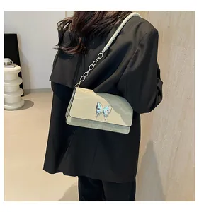 Close-up of mint green pleated leather bag with a metallic butterfly clasp and chain
