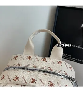 Detail of a beige leather backpack with cartoon rabbit prints and durable nylon handles