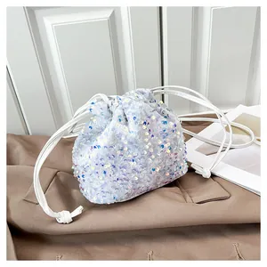 Détail du sac seau à paillettes blanches avec fini iridescent et sangle en PU