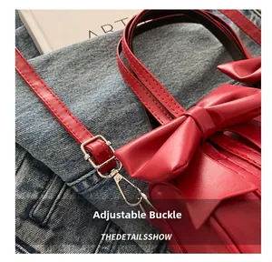 Detailed close-up of red PU leather bag with adjustable metal buckle and stylish bow