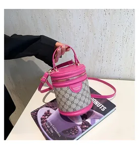Detail of a pink leather and patterned canvas bucket bag with adjustable shoulder strap