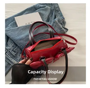 Interior view showing the large capacity of the red pleated bow cylinder shoulder bag