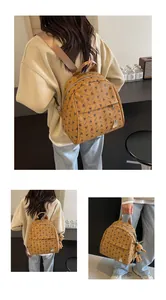 Detail view of ginger yellow mini backpack with black rabbit print and cute charms