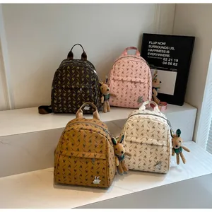 Detailed view of mini PU leather backpacks with bunny patterns and cute plush charms