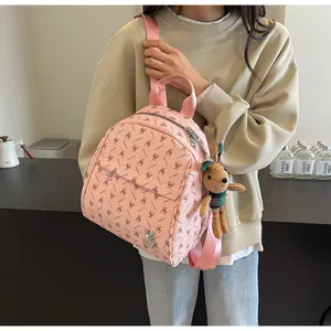 Pink monogram backpack with cute rabbit patterns and a small plush bunny charm detail