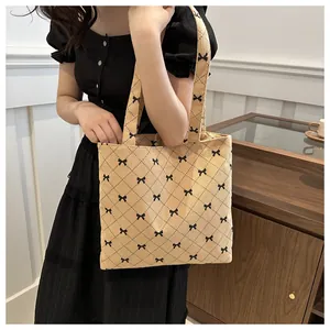 Sac fourre-tout en velours côtelé beige avec petits nœuds noirs et motif matelassé
