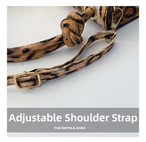 Macro detail of adjustable woven shoulder strap with gold metal buckle on leopard handbag