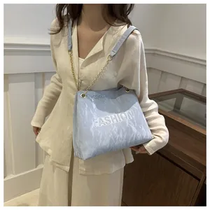 Détail du cabas bleu clair avec texture plissée, embossage FASHION et chaîne dorée