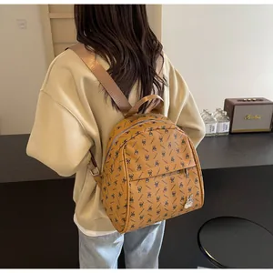 Detailed view of ginger yellow PU leather backpack with rabbit patterns and metal charm