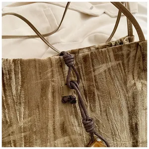 Detail of brown velvet tote bag featuring unique crushed texture and amber pendant