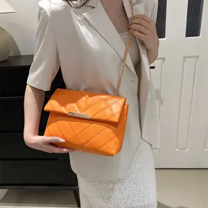 Orange V-quilted chain crossbody bag for women with golden metal strap and flap closure