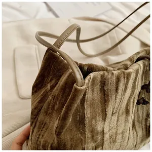 Detail of metallic bronze velvet fabric with micro-pleated texture on a large tote bag