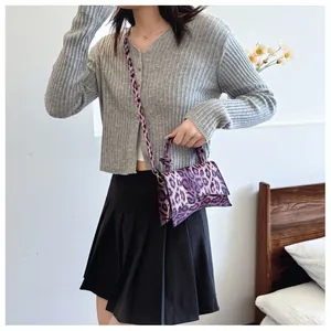 Chic purple leopard print hourglass bag with woven handle shown on model in a stylish setting