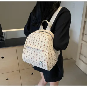 Detail of cream white PU leather backpack with cartoon rabbit prints and metal pendant