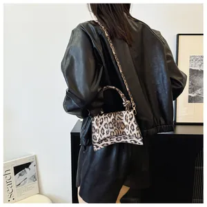 Modern leopard print trapezoid crossbody bag styled on a model in a minimalist room