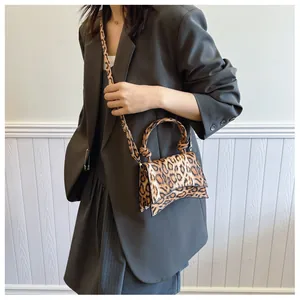 Detail of leopard print small square bag with unique curved base and knotted handle