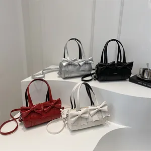 Pleated cylinder handbag with bow detail in silver, black, red, and white colors