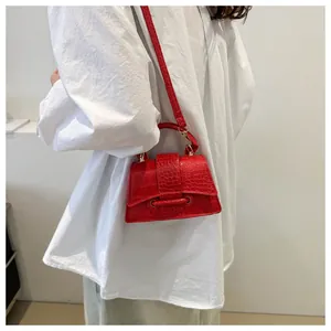 Detail van de rode mini-handtas met krokodillentextuur, schouderriem en handvatontwerp