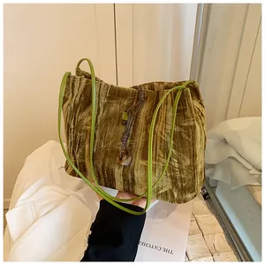 Detailed shot of velvet bucket bag with bamboo leaf tie-dye pattern and cord knot