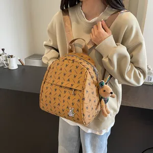 Brown faux leather backpack with bunny print, zip pockets and plush toy keychain