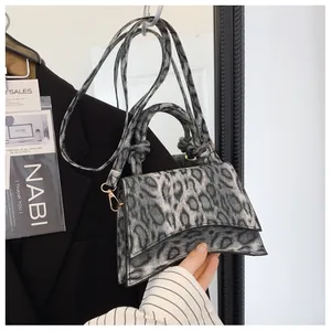 Detailed view of grey leopard print handbag with unique curved hourglass bottom design