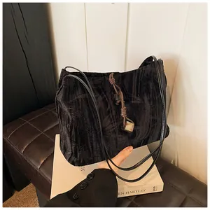 Detail of black crushed velvet tote bag featuring a vintage knot and square bead charm
