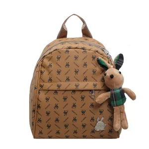 Light brown printed leather backpack with bunny patterns and a cute plush toy pendant
