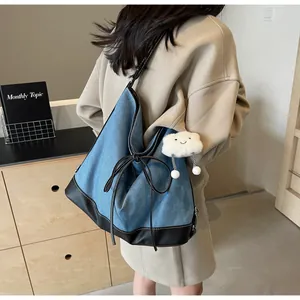 Detail of blue denim tote bag with leather拼接, bow drawstring and cloud charm