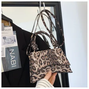 Macro view of leopard print texture on a square handbag with elegant knotted handle