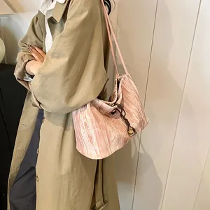 Pink pleated shoulder bag for women with drawstring and gold charm in minimalist style
