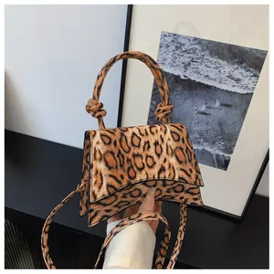 Detail of leopard print handbag featuring a unique hourglass curved base and knotted handle