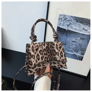 Detail showing the leopard print faux fur texture and knotted handle on this handbag