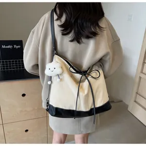 Detail of canvas tote bag with contrast black trim and cute cloud plush charm accessory