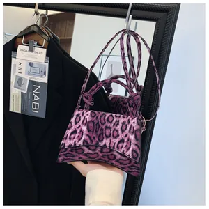 Detail view of purple leopard print hourglass handbag with unique knotted handle